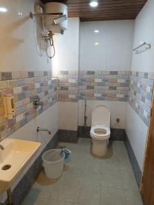 a bathroom with a toilet and a sink at Hotel LAAKHAN BY GHUMO UDAIPUR in Udaipur