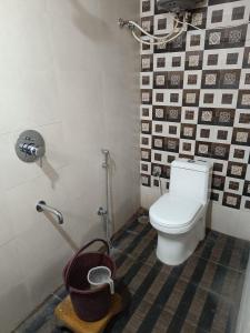 a bathroom with a toilet and black and white tiles at Hotel LAAKHAN BY GHUMO UDAIPUR in Udaipur