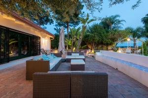 a patio with couches and tables and a building at Villa with pool & jacuzzi in Taormina