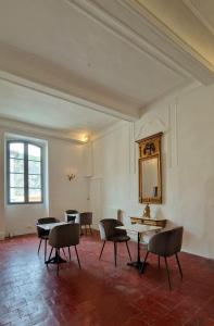 an empty room with chairs and tables and a mirror at La tour de Pezene in Anduze