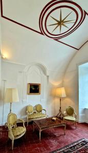 a living room with a table and chairs and a clock on the ceiling at La tour de Pezene in Anduze