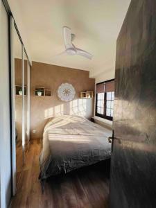 een slaapkamer met een bed en een plafondventilator bij Charmant deux pièces au calme in Mougins
