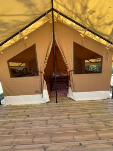 a tent with a wooden floor and a table inside at Camping Beaussement Samouraï in Chauzon