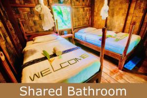two beds in a room with the words shared bathroom at SpringRiver Resort in Ban O