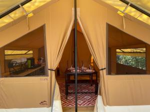 a tent with two windows and a table in it at Camping Beaussement Samouraï in Chauzon