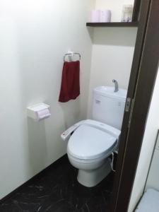 ein Badezimmer mit einem weißen WC und einem roten Handtuch in der Unterkunft YUFUKANⅡ in Yufu