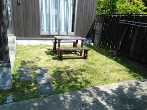a picnic table and bench in the grass at YUFUKANⅡ in Yufu