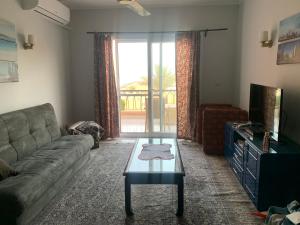 a living room with a couch and a tv at Chalet empire resort ain sokhna in Ain Sokhna