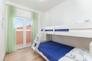 een slaapkamer met een stapelbed en een balkon bij Kuća Lana in Medulin