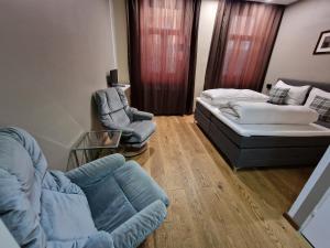 ein Wohnzimmer mit einem Sofa und 2 Stühlen in der Unterkunft Aparthotel LAAERBERG in Wien