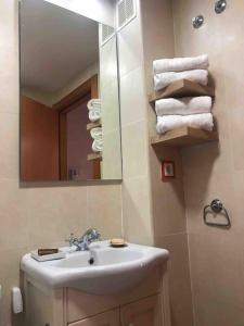 a bathroom with a sink and a mirror and towels at El Gurugú, apartamento con jardín en la playa de Barro in Barro de Llanes