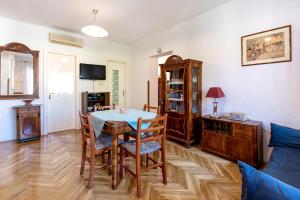 een woonkamer met een tafel en stoelen en een bank bij Zoe Apartment in Split
