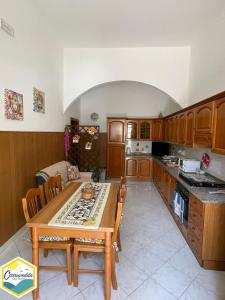 阿沃拉的住宿－Casa Carruvedda，厨房配有木桌和桌椅