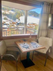 萊熱的住宿－L'OURALOU - Vue panoramique，一张桌子和一把椅子,位于带大窗户的房间里