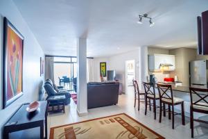 ein Wohnzimmer und eine Küche mit einem Tisch und Stühlen in der Unterkunft 304A Santorini -Margate RSA in Margate