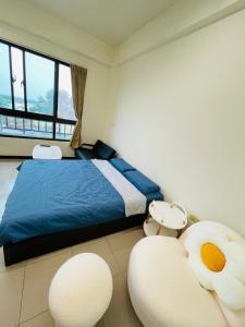 a bedroom with a bed and two white chairs at American Style Rende in Tainan