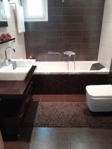 y baño con bañera, lavabo y aseo. en FAMILY HOUSE en Kavala