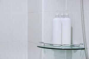 two white bottles on a shelf in a bathroom at Seoul Dalbit Dongdaemun Guesthouse in Seoul