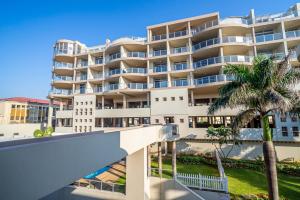 un gran edificio de apartamentos con una palmera en 304A Santorini -Margate RSA, en Margate