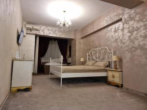 a bedroom with a white bed and a chandelier at Studio Rendez-vous Alba Iulia in Bucharest