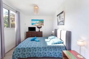a bedroom with a bed with a blue pillow on it at L’escapade créole jacuzzi privatif Bungalow Ananas in Saint-Joseph