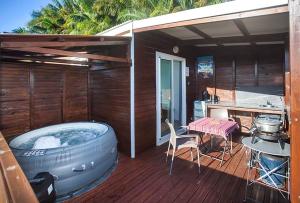 un bain à remous sur la terrasse d'une maison dans l'établissement L’escapade créole jacuzzi privatif Bungalow Ananas, à Saint-Joseph