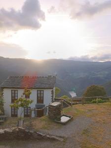 ein kleines Haus auf einem Hügel mit Aussicht in der Unterkunft Apartamentos Rurales San Esteban de los Buitres - Illano 