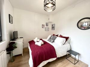 a bedroom with a bed with a red blanket at Le JOY, studio au coeur de la ville in Beauvais
