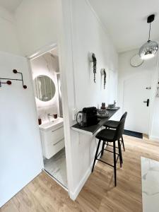une petite cuisine blanche avec une table et une chaise dans l'établissement Le JOY, studio au coeur de la ville, à Beauvais