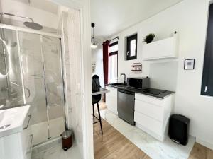 a kitchen with a shower and a sink and a counter at Le JOY, studio au coeur de la ville in Beauvais