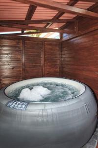 a large hot tub in a room with a wooden wall at L’escapade créole jacuzzi privatif Bungalow Ananas in Saint-Joseph