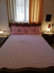 a bedroom with a large bed with a pink bedspread at Μαγευτική θέα στη θάλασσα in Loukísia