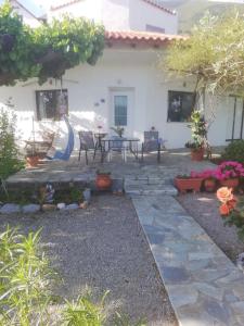 a house with a patio with a table and some plants at Μαγευτική θέα στη θάλασσα in Loukísia