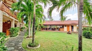 a yard with palm trees in front of a house at Alona42 Resort in Panglao