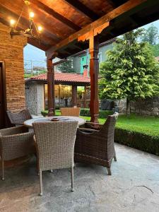 un patio con mesa y sillas bajo una pérgola en Guest House EGO, en Bratsigovo