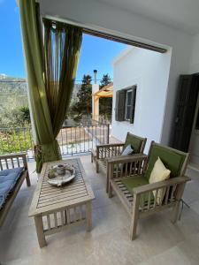 a patio with chairs and a table and a window at Maria’s Cottage House in Kalymnos