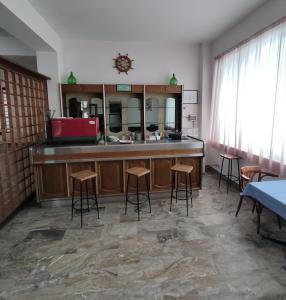 Cette chambre comprend un comptoir avec tabourets et un miroir. dans l'établissement Hotel Il Dollaro, à Villa San Giovanni