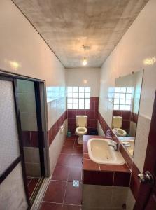 a bathroom with two toilets and a sink and a mirror at Rummy Hostal in Uyuni