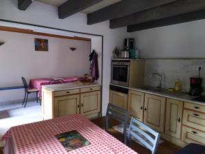 a kitchen with a table and a kitchen with a table and a table at Chez Gueguette in Saint-Jean-Saint-Gervais