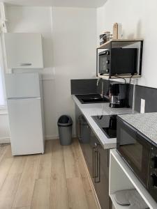 cocina con electrodomésticos blancos y suelo de madera en Charmant logement à 2 pas de la plage en Le Portel