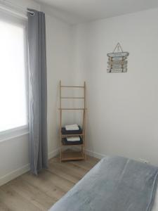 1 dormitorio con cama, estante y ventana en Charmant logement à 2 pas de la plage en Le Portel
