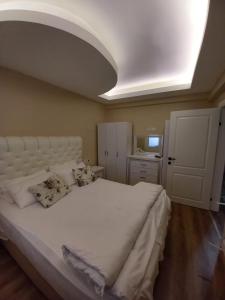 a bedroom with a large white bed with pillows on it at Dilmac Hotel in Gelibolu