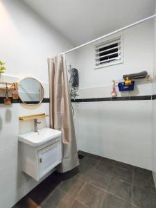 een badkamer met een wastafel en een spiegel bij DH Merlimau Homestay in Merlimau