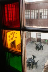 a view through a window of a courtyard with tables and benches at Rummy Hostal in Uyuni