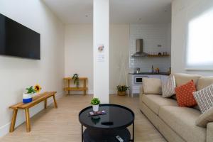 a living room with a couch and a table at Apartamentos Magna Sevilla in Seville