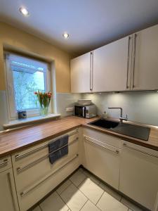 a kitchen with white cabinets and a window at Ferienhaus Hoher Meißner in Germerode