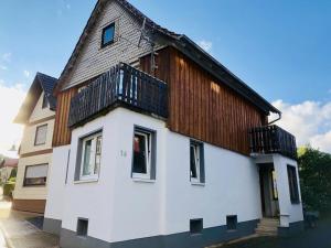 a small white house with a wooden roof at Ferienhaus Hoher Meißner in Germerode