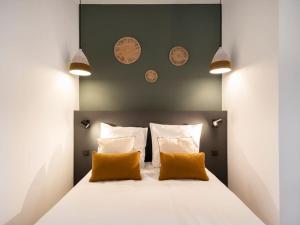 um quarto com uma cama grande e 2 almofadas laranja em Le Coquet des Trois-Maisons avec parking privatif em Nancy