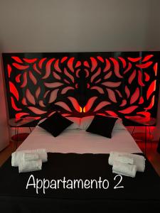 una cama con un patrón rojo y negro en ella en Brimiky House, en Siracusa