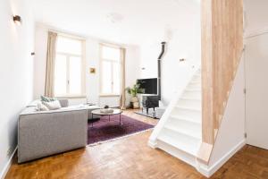 - un salon avec un canapé et un escalier dans l'établissement The Sebastian, à Anvers